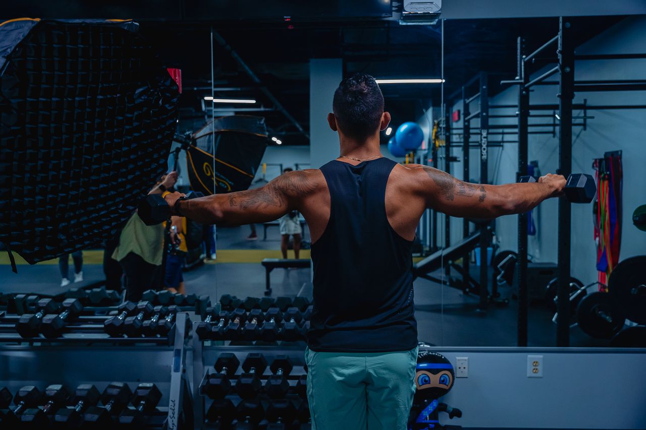Mastering the First Impression: Your intriguing post title goes here Adult male working out with dumbbells in a gym, focused on building strength and fitness.